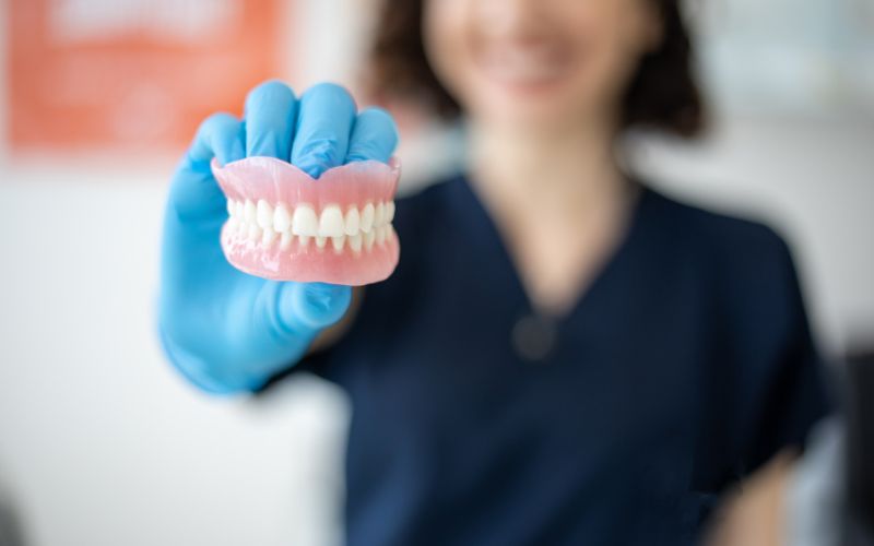 a dentist holding a denture